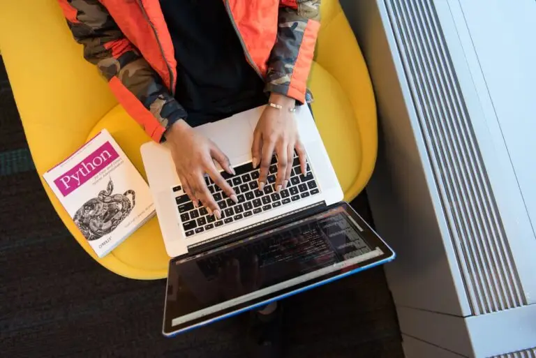 Person Using Macbook Pro and Python book