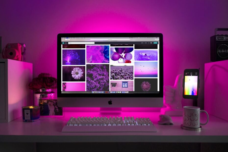 Silver Imac Displaying Collage Photos with Pink Lighting.
