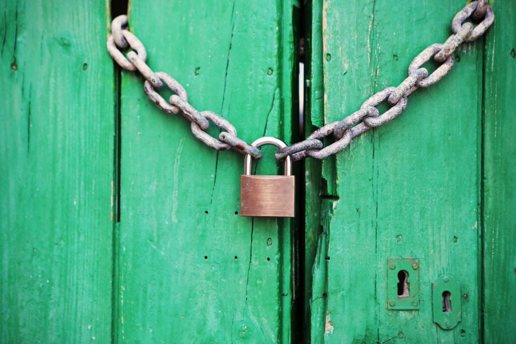 A lock and chain barring two wooden green doors, artistic